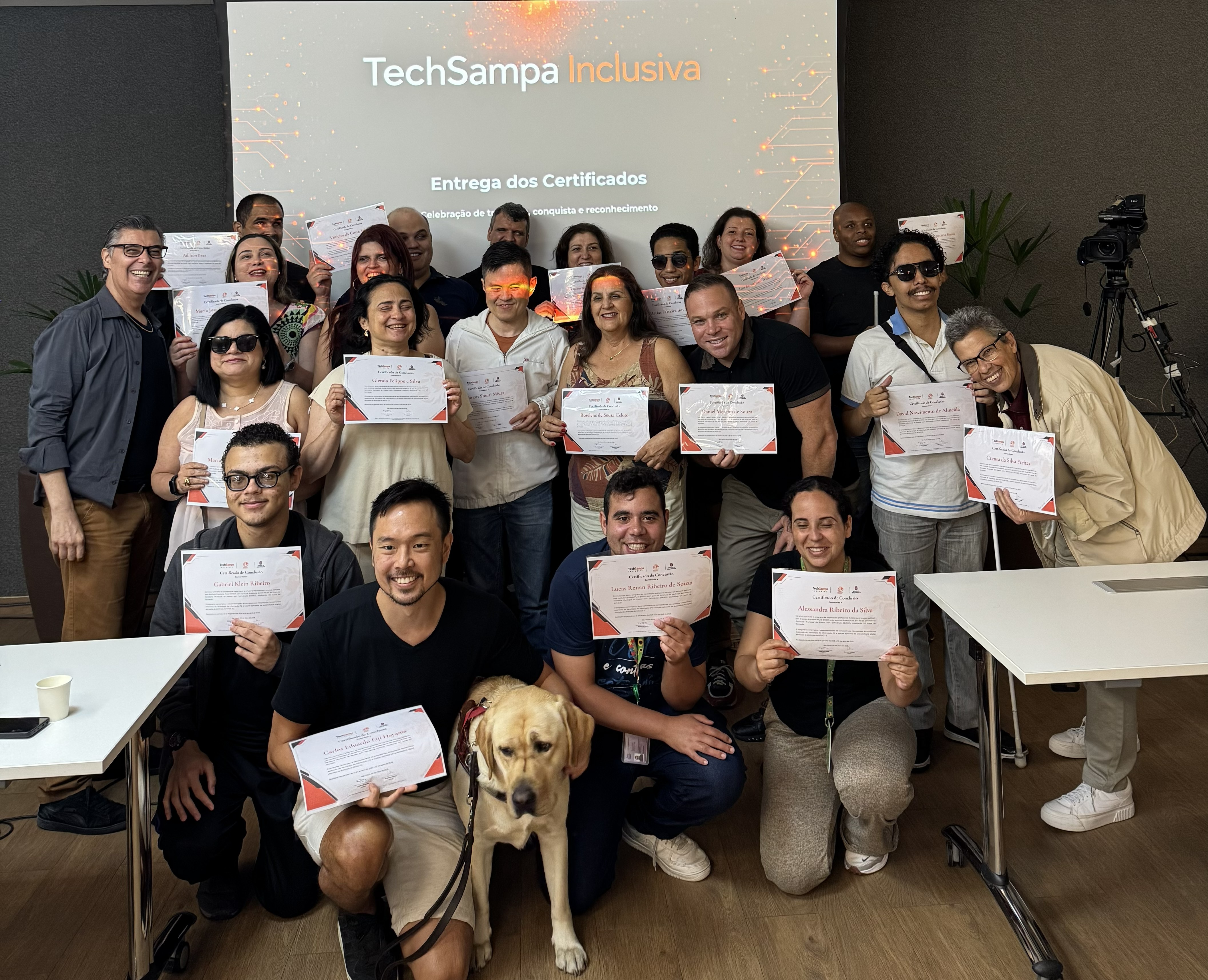 Grupo de participantes da TechSampa Inclusiva exibe certificados de conclusão de uma formação em tecnologia e inclusão.